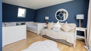 Une chambre à coucher avec un lit, des tables de chevet, une fenêtre et une armoire blanche.