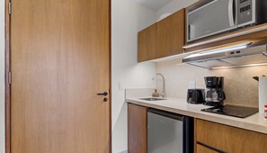 Cocina compacta con microondas, tostadora y cafetera.