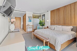 Un dormitorio moderno con una cama grande, cabecera de madera y vistas al exterior.