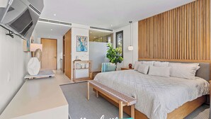 A modern bedroom with a large bed, wooden headboard, and a view of the outdoors.