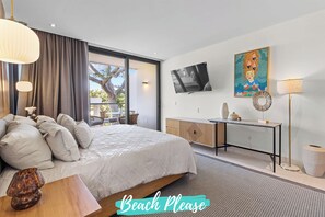 Un dormitorio moderno con una cama grande, un escritorio y un televisor.