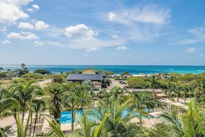 Ein Resort mit Pool, Palmen und Blick auf den Ozean.