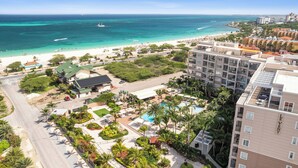 A resort with a pool, palm trees, and a beach. - Bocobay LeVent Condos (Oranjestad)