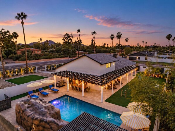 A residential property with a swimming pool, outdoor seating area, and a view of the surrounding landscape.
