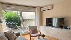 A modern living room with a sofa, a chair, a small table, and a TV. - Delightful Studio With Private Parking, Beaulieu (Beaulieu-sur-Mer)