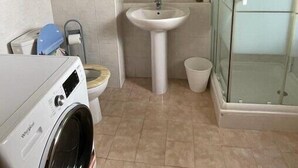 A compact bathroom with a washing machine, a sink, and a glass shower enclosure. - Delightful Studio With Private Parking, Beaulieu (Beaulieu-sur-Mer)