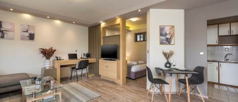 A modern apartment with a living area, dining space, and kitchenette.