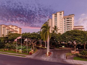 A multi-story hotel with a landscaped entrance, palm trees, and American flags. - Marriott's Ko Olina Beach Club 1 BR OCEAN VIEW (Kapolei)