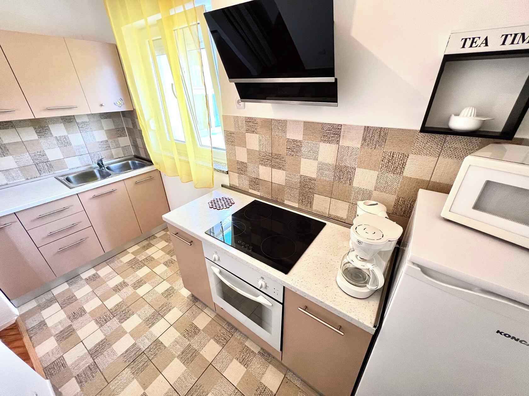 A compact kitchen with a microwave, stove, and sink.