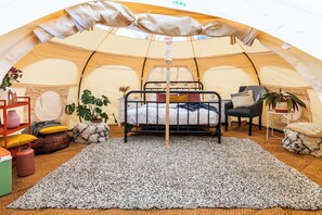 A cozy tent with a bunk bed, a small table, chairs, and potted plants. - Glamping - The Natterjack, Bath (Charlcombe)