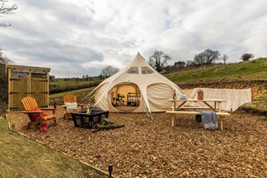 A tent with a sleeping area, a small wooden structure, and two chairs. - Glamping - The Natterjack, Bath (Charlcombe)