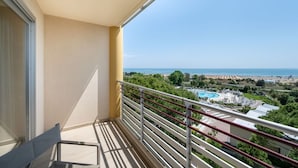 A balcony with a clear view of a pool, beach, and distant landscape. - Peaceful stay with spa near the marina (Bibione)