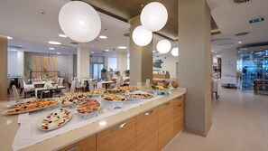 Disposição de buffet com diversos alimentos e design de interiores moderno.