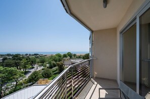 Ein Balkon mit Blick auf Meer und Grün.