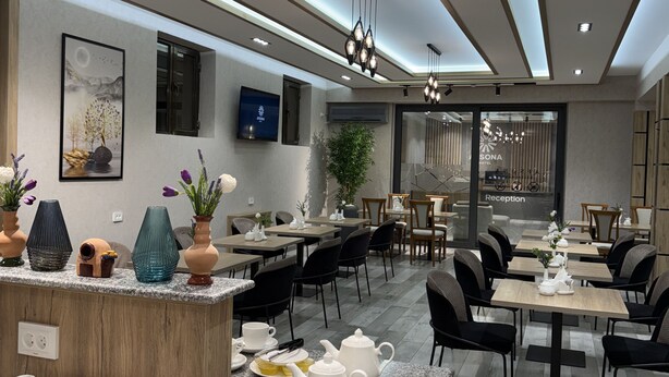 A modern hotel lobby with a reception desk, seating areas, and a large window. - Afsona hotel (Qarshi)