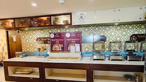 A reception area with a counter, display boards, and a patterned wall. - SS LUMINA HOTEL (Bengaluru)