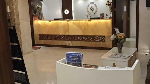 A hotel reception area with a reception desk, a sign for 'Stellar Banquet Hall', and a reception counter. - SS LUMINA HOTEL (Bengaluru)