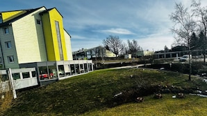 A modern building with a yellow facade and a glass extension. - Werrapark Hotel Heubacher Höhe (Masserberg)