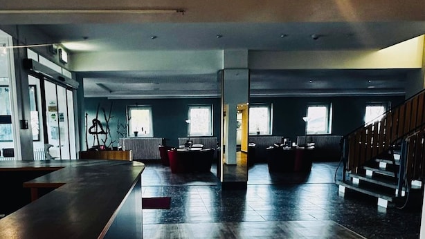 A spacious room with a wooden floor, a long counter, and a staircase. - Werrapark Hotel Heubacher Höhe (Masserberg)