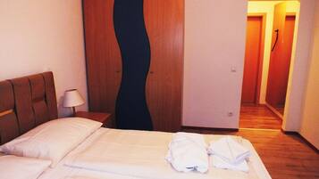 Ett hotellrum med en säng, ett nattduksbord, en lampa, en garderob och en hall.