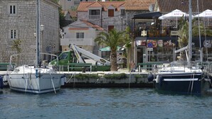 A marina with boats docked, a crane, and buildings with balconies.