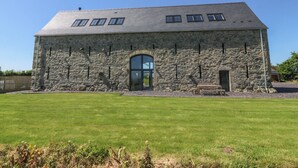 Un edificio in pietra con tetto spiovente e un'ampia entrata ad arco.