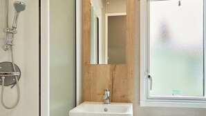 A bathroom with a shower, a sink, and a toilet.