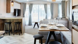 Una cocina moderna con comedor, taburetes de bar y un sofá.
