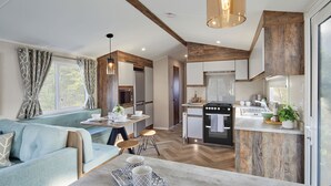 A modern kitchen with wooden accents, a dining area with a blue sofa, and a breakfast bar.