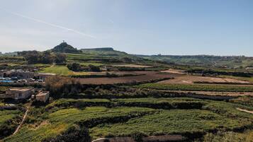 A rural landscape with terraced fields, a stone church, and a small village with traditional buildings.