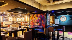 A restaurant with a vibrant lion mural, tables, and bar seating. - Zayed Hotel & Restaurant  (Giza)