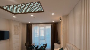 Habitación de hotel con cama, escritorio, silla y televisión.