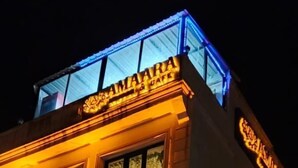 Un edificio con letreros iluminados que dicen "AMAARA" y "KONAL & CAFE".