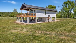 A single-story house with a covered porch, a small deck, and a large open lawn area. - Elk View-Access Elk River-Rural Acreage-Huge Patio (Noel)
