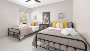 A bedroom with two beds, a ceiling fan, a window with blinds, and wall decor. - Elk View-Access Elk River-Rural Acreage-Huge Patio (Noel)