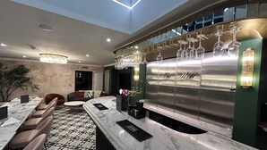 A bar area with a marble countertop, hanging wine glasses, and a sign reading "The Mill". - The Mill Sharnbrook (Bedford)