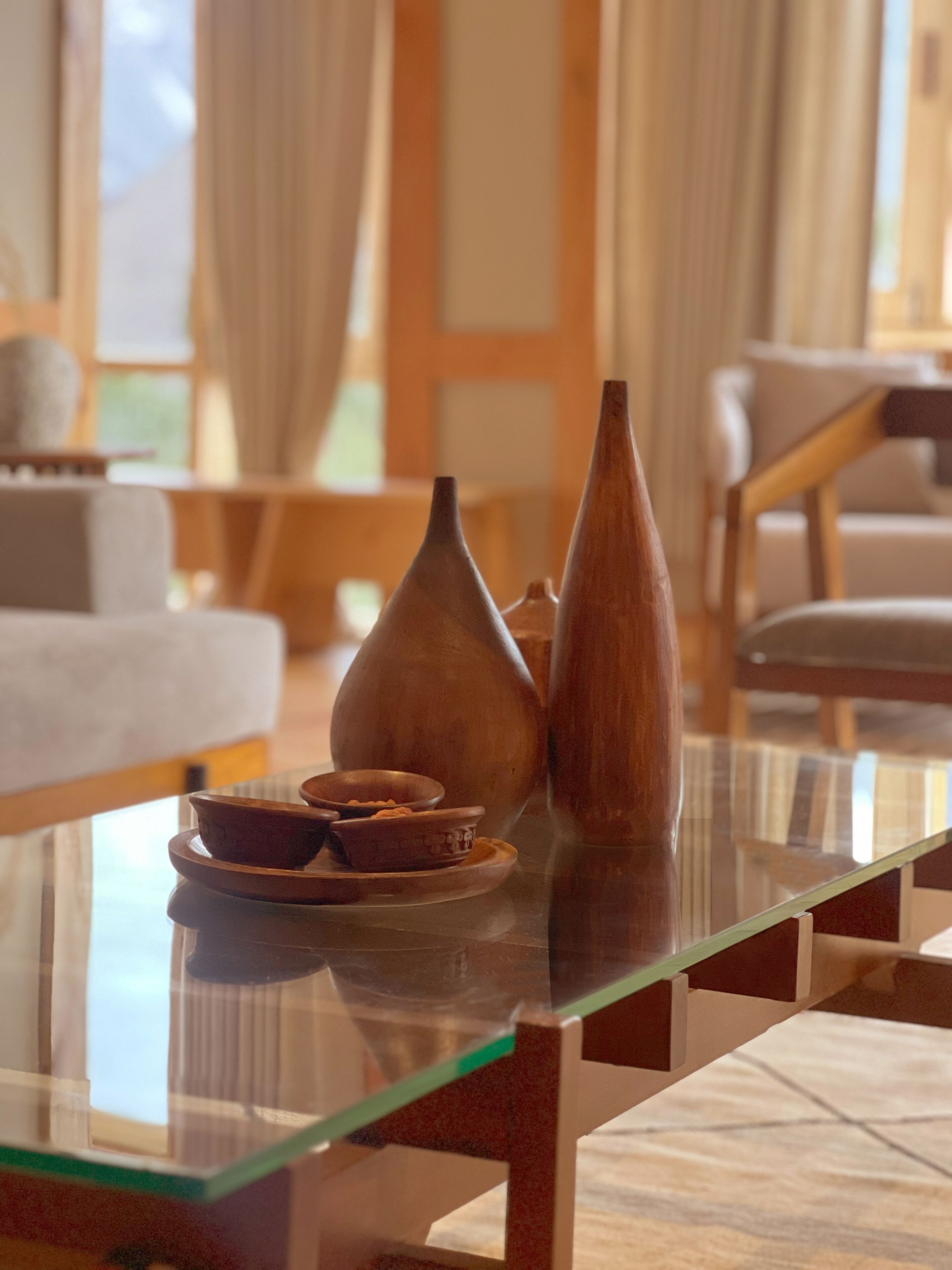 A glass-top table with ceramic vases and bowls.