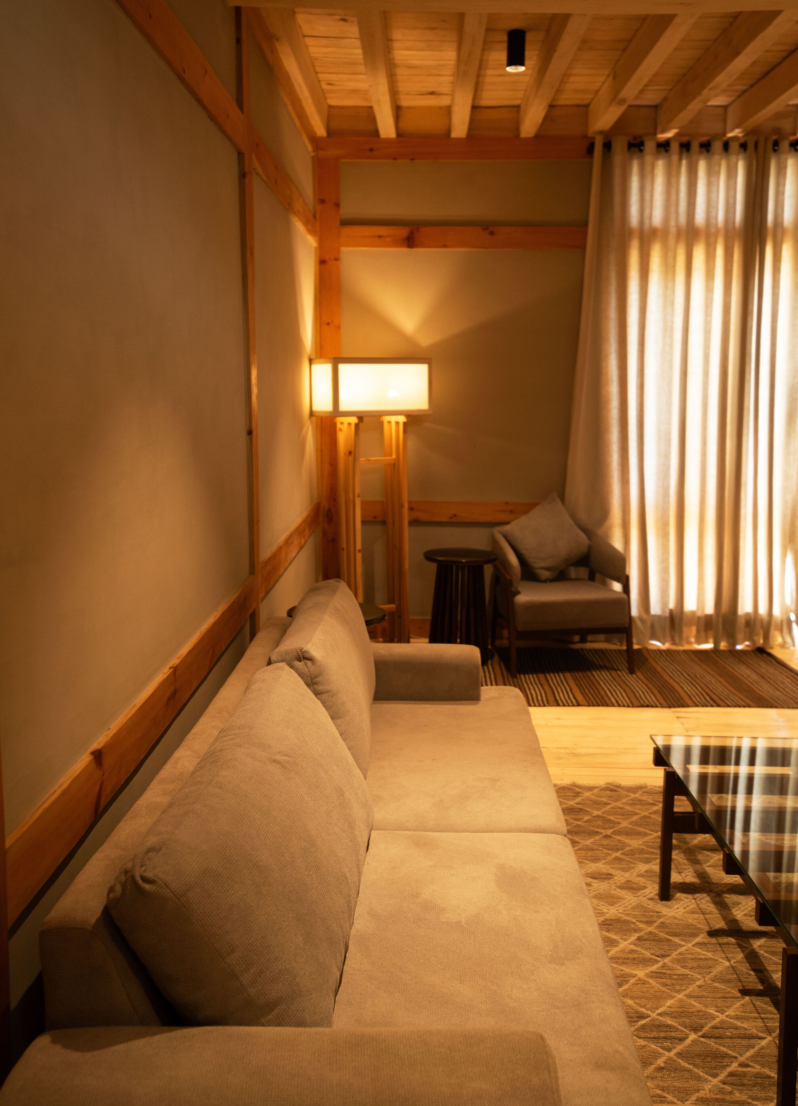 A cozy room with a sofa, a small table, and a chair.