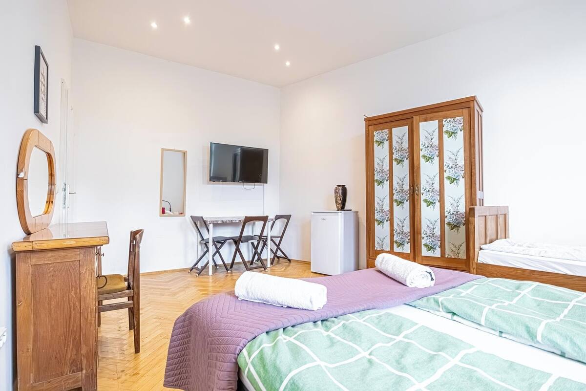 Une chambre à coucher comprenant un lit, un bureau, une chaise, une télévision et une armoire.