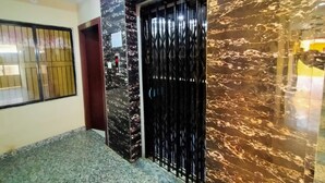 A hallway with a black metal gate, marble walls, and a ceiling with LED lighting. - DhamStay Hotel UK Palace Near Beach Puri (Puri)