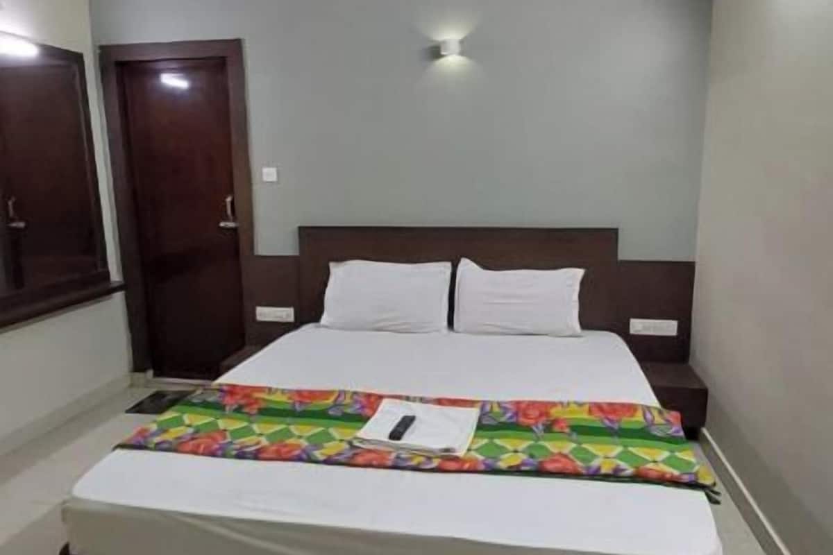 Un dormitorio con cama, ventilador de techo, puerta y lámpara.
