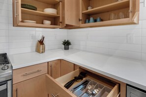 Enjoy cooking in this well-equipped kitchen with a cabinet, stainless steel range hood, and convenient dishwasher.