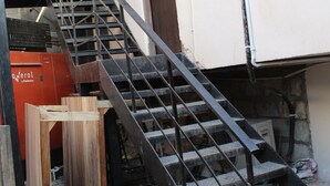 Un escalier menant à un bâtiment sur lequel on peut lire l’inscription « Résidence universitaire Paradise A.C. ».