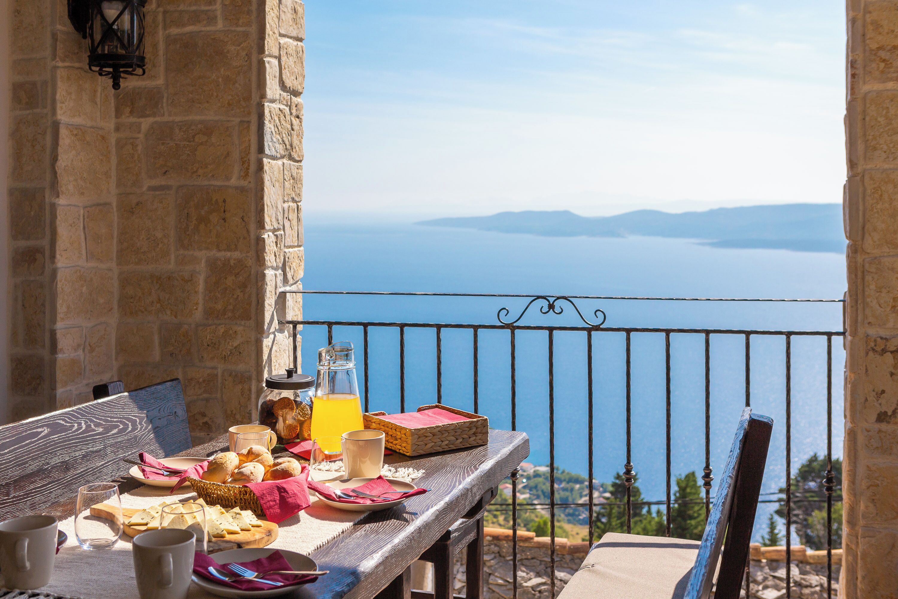 A table with breakfast items and a view of the sea.