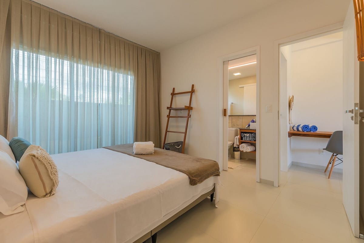 Ein Hotelzimmer mit einem Bett, einer Leiter, einem Schreibtisch und einem Sessel.