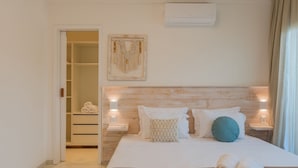 A neatly made bed with a brown blanket, two rolled towels, and a headboard with a wooden finish. - Kite Star Cumbuco By Carpediem (Caucaia)