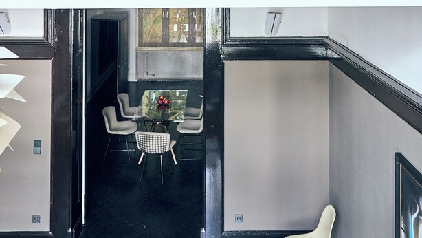 Een modern interieur met een glazen trap die twee verdiepingen verbindt.