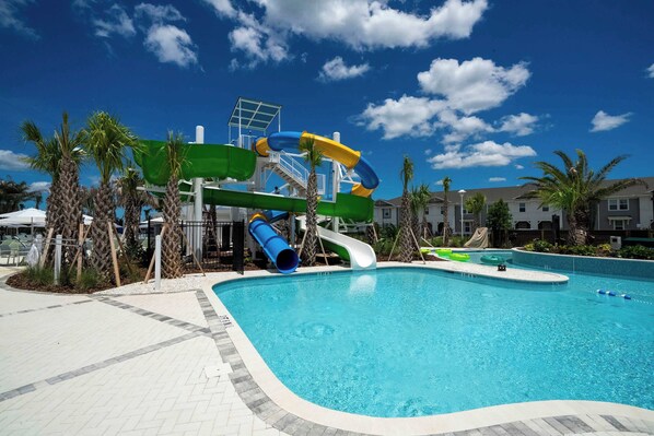 A swimming pool with slides and a lifeguard tower. - Game Room & Private Pool! Windsor Cay 5BR Home (Clermont)