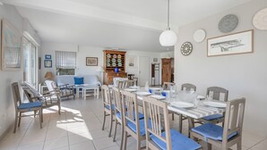 A dining area with a table set for four, surrounded by wooden chairs with blue cushions. - 50m from the beach, house with garden for 10 (Piriac-sur-Mer)