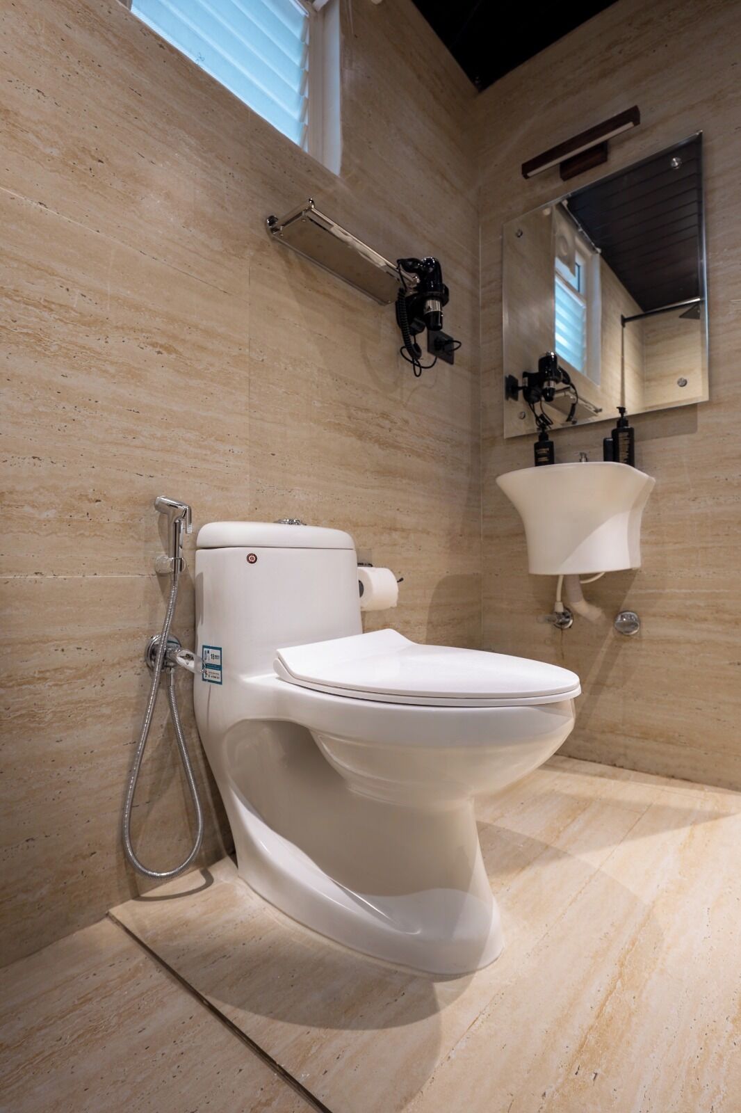 A modern bathroom with a toilet, shower, and sink.